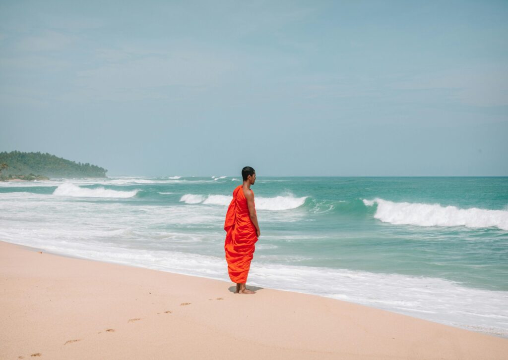 Monk stands by sea